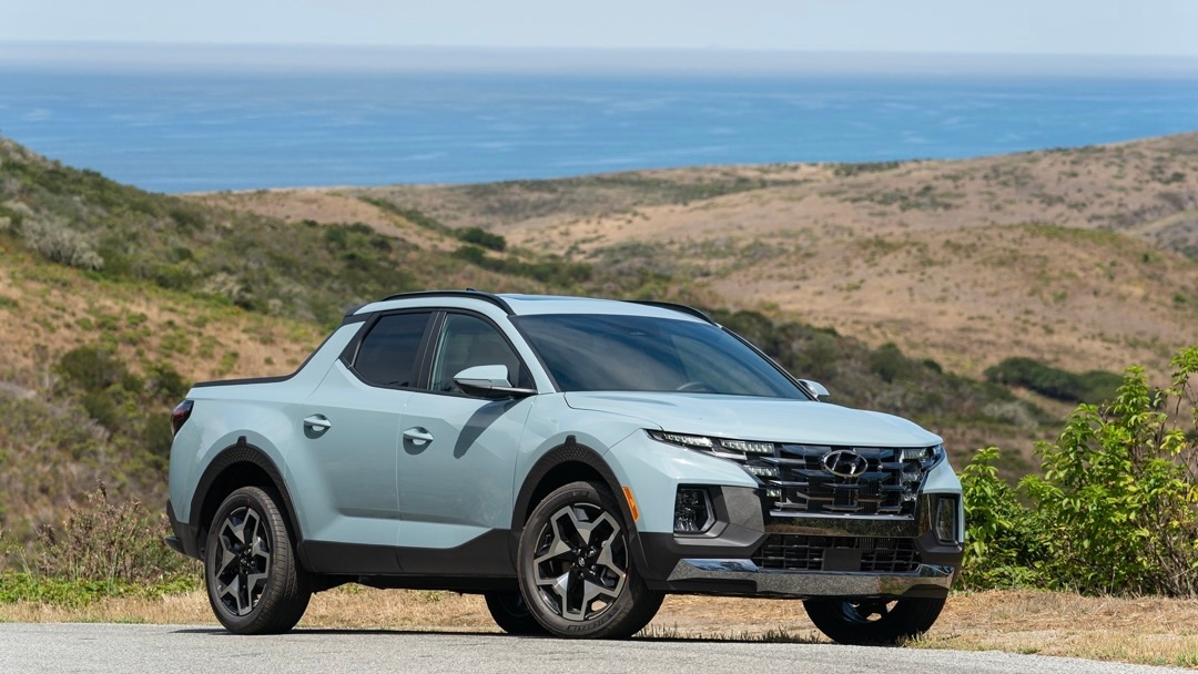 Le Hyundai Santa Cruz stationné sur l'asphalte avec un décor de montagne.