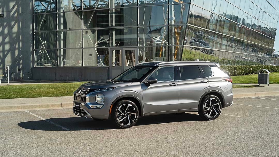 Le Mitsubishi Outlander stationné devant un immeuble en verre.