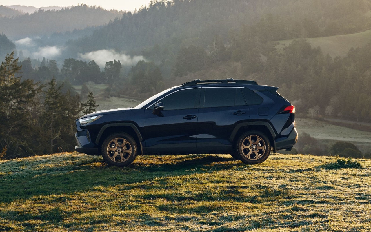 Le Toyota RAV4 hybride PHEV 2024 stationné dans un champs au petit matin.