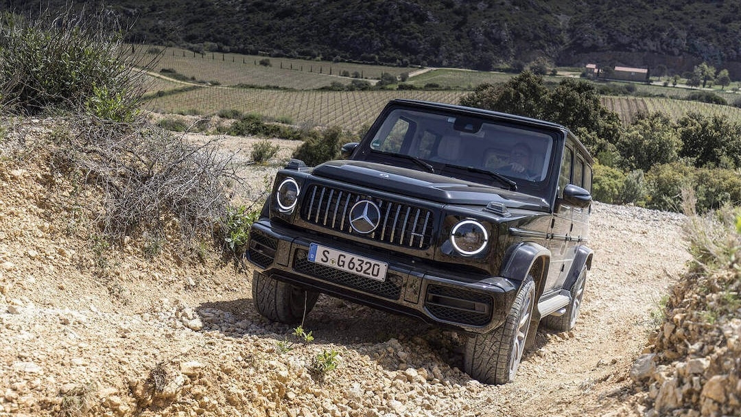 Le Mercedes Classe G qui roule sur un chemin de gravier en montagne.