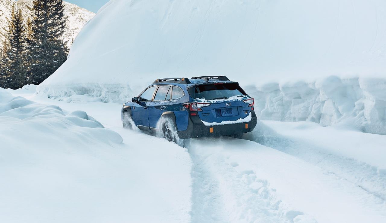 La subaru outback roulant dans la haute neige.